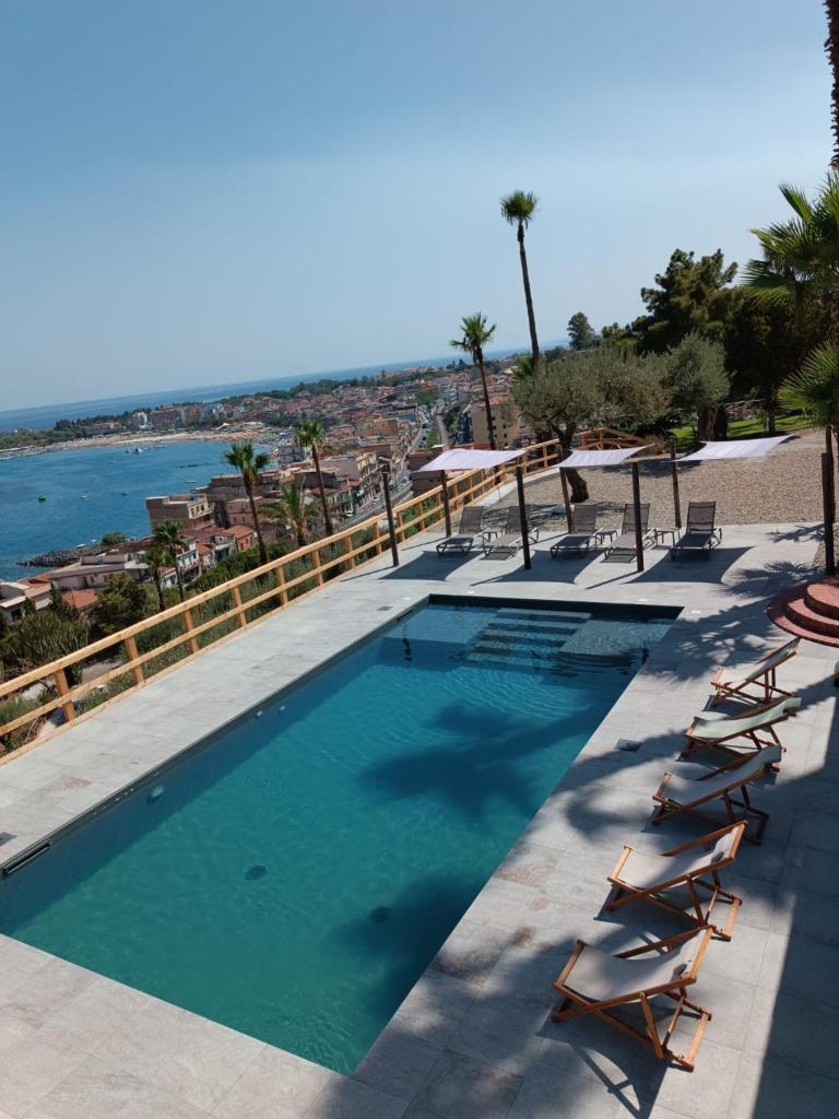 une piscine avec des chaises longues et l'océan dans l'établissement LUXURY VILLA Vittorianna Etna- Taormina & Seaview with Pool, à Giardini Naxos
