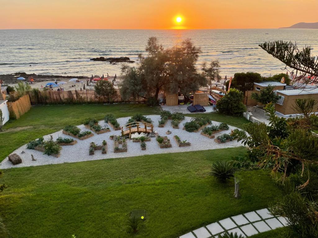 une vue aérienne d'un jardin sur la plage au coucher du soleil dans l'établissement Hotel Acciaroli, à Acciaroli