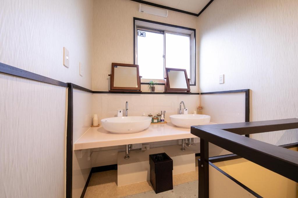 une salle de bain avec deux lavabos et deux miroirs dans l'établissement 別府 鉄輪温泉 萬力屋別館 ManrikiyaBekkan Beppu Kannawa, à Beppu