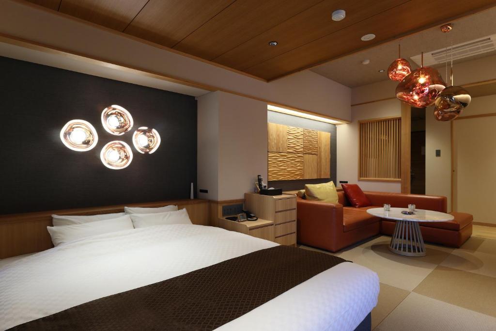 une chambre avec un lit et un salon dans l'établissement Yorokobinoyado Takamatsu, à Kusatsu