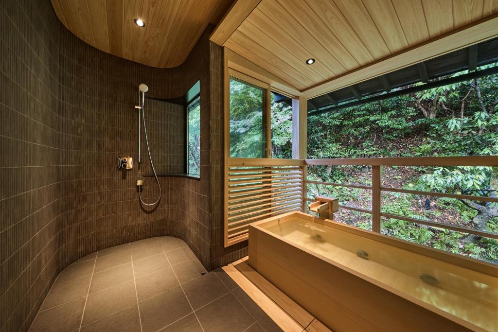 une salle de bain avec une baignoire et une fenêtre dans l'établissement Nishimuraya Honkan, à Toyooka