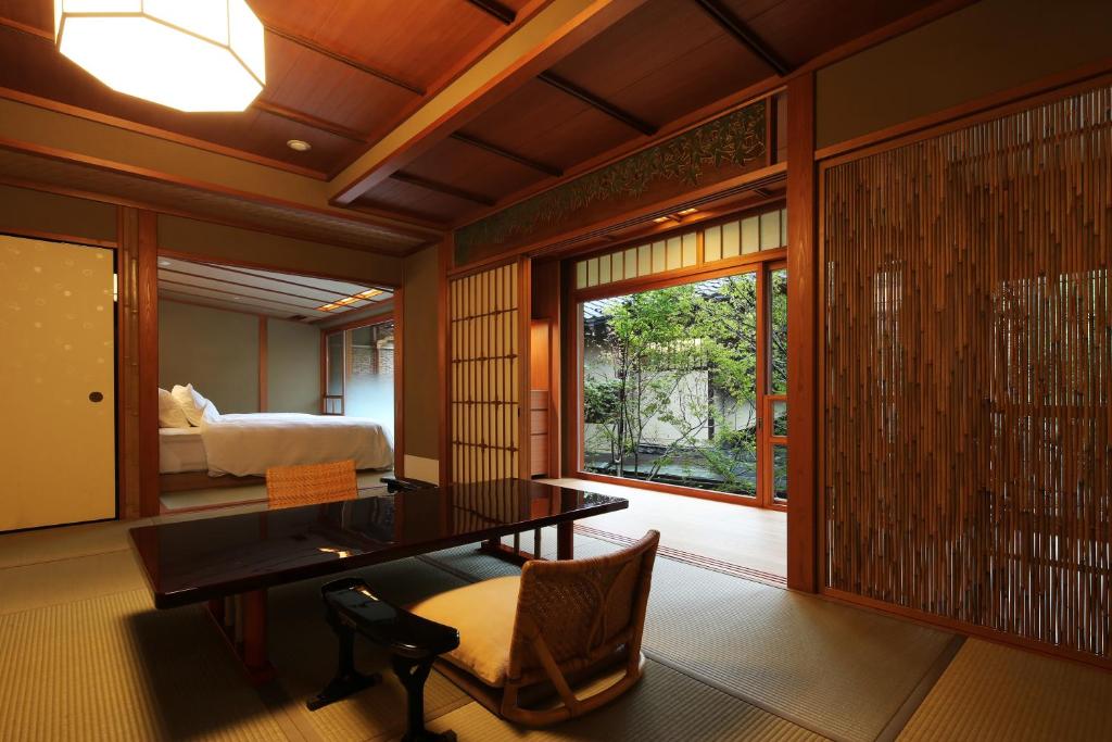 Cette chambre comprend un bureau, un lit et une fenêtre. dans l'établissement Nishimuraya Honkan, à Toyooka