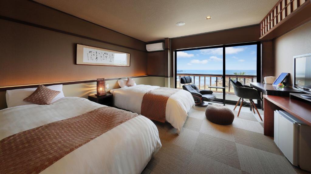 Cette chambre comprend deux lits, un bureau et un balcon. dans l'établissement 季粋の宿 紋屋, à Hongō 46 autres photos