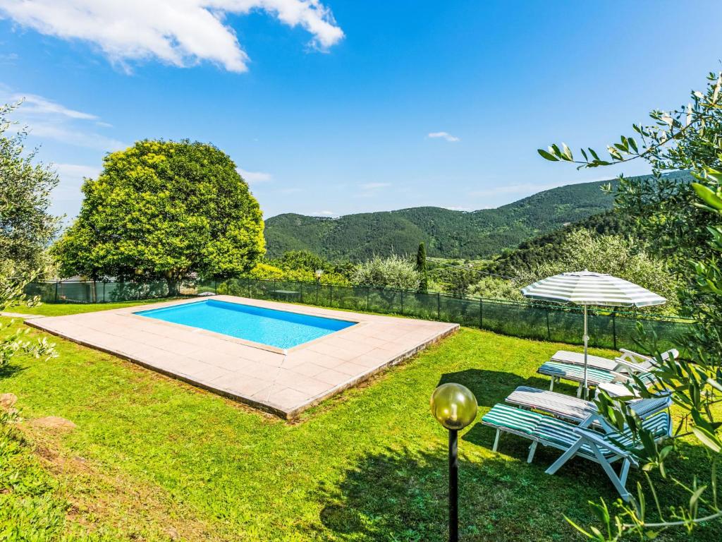 - une piscine dans une cour avec 2 chaises et un parasol dans l'établissement Villa Luana by Interhome, à Ruota