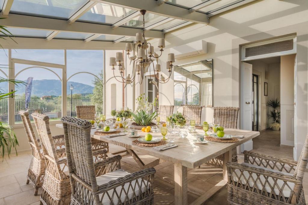 une salle à manger avec une table, des chaises et un lustre dans l'établissement Villa Sunkiss: Luxury Farmhouse with Tuscan Flair, à Montecarlo