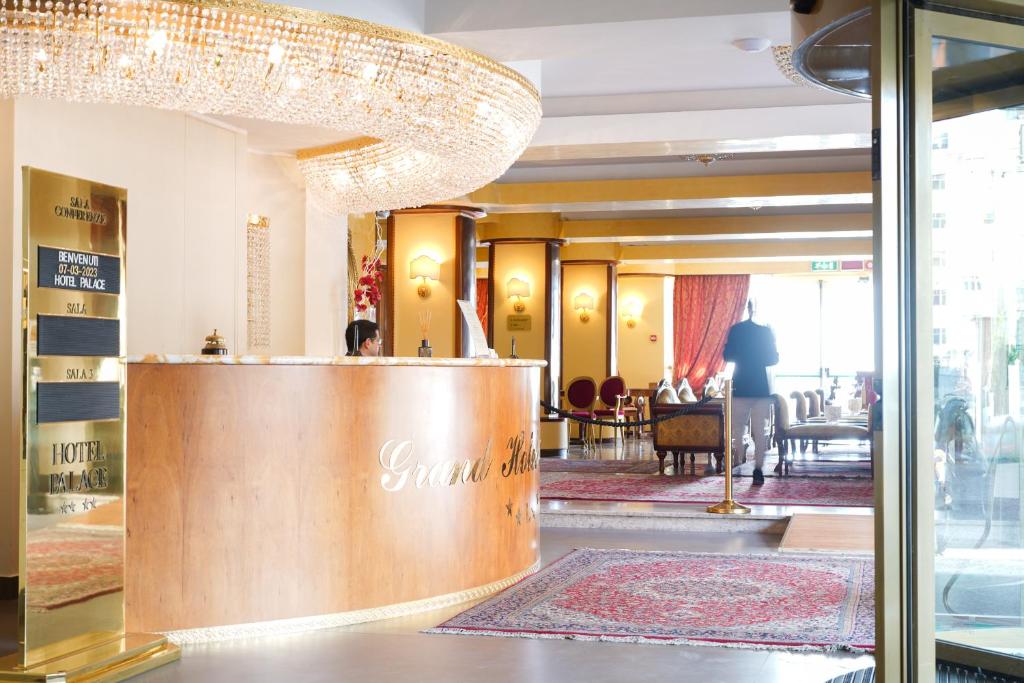 un hall d'hôtel avec un lustre dans l'établissement Hotel Palace, à Catanzaro Lido