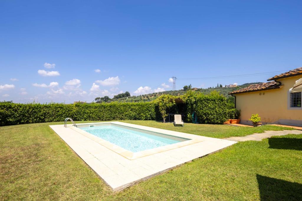 une piscine au milieu d'une cour dans l'établissement Villa il Fienile by VacaVilla, à Lamporecchio