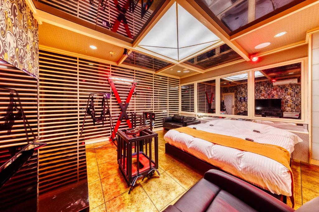 une chambre avec un lit, un canapé et une télévision dans l'établissement HOTEL ABnormal (Adult Only), à Izumiotsu