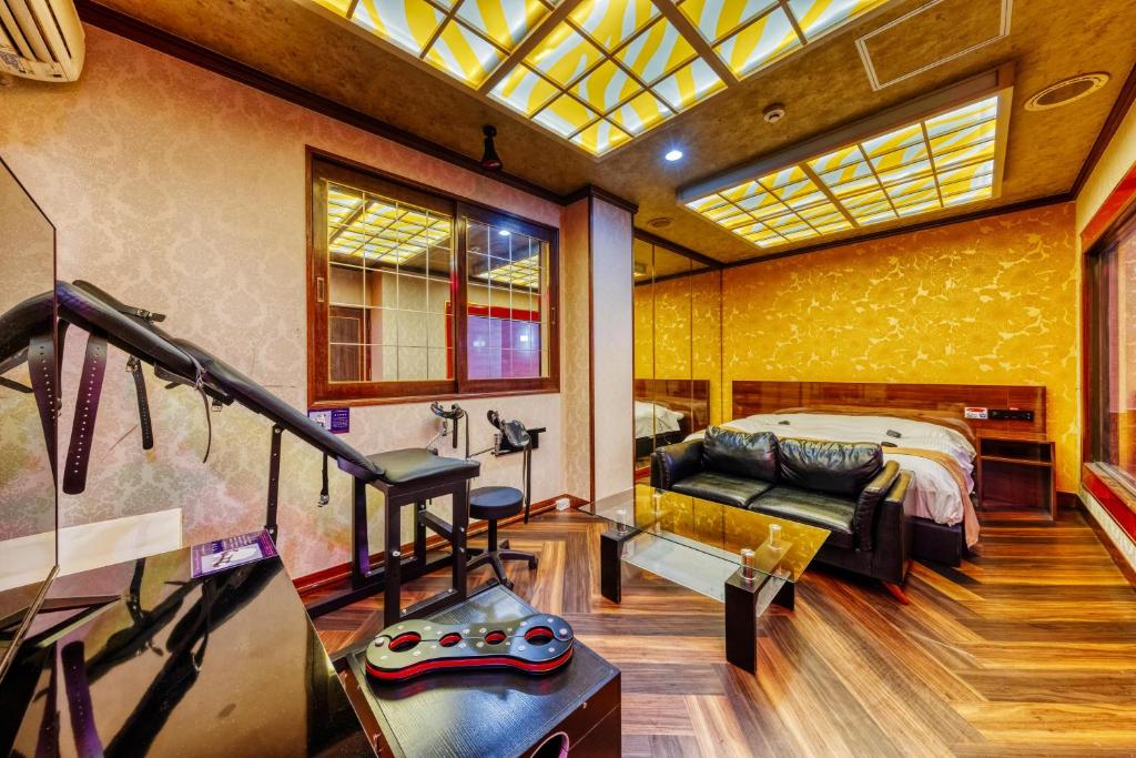 une chambre avec un lit et un canapé dans une pièce dans l'établissement HOTEL ABnormal (Adult Only), à Izumiotsu