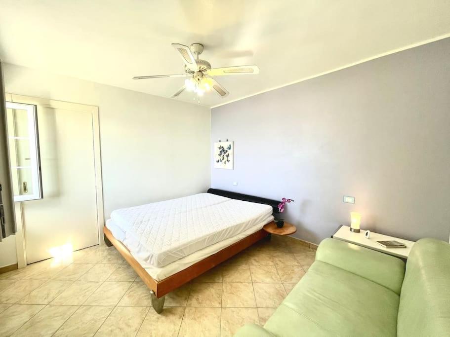 - une chambre avec un lit, un canapé et un ventilateur de plafond dans l'établissement Villa Licia, à Gardone Riviera