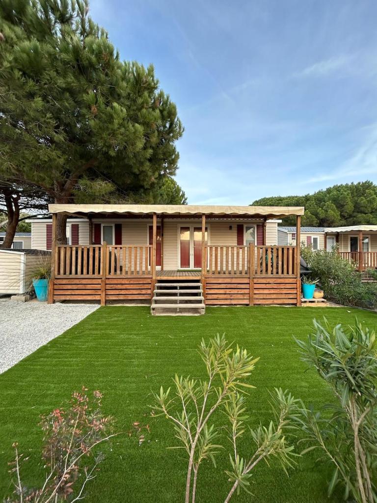 une maison avec un porche et une cour dans l'établissement Mobil'home Canet en Roussillon, à Canet