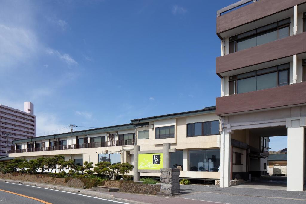 un immeuble d'appartements dans une rue de la ville dans l'établissement 季粋の宿 紋屋, à Hongō