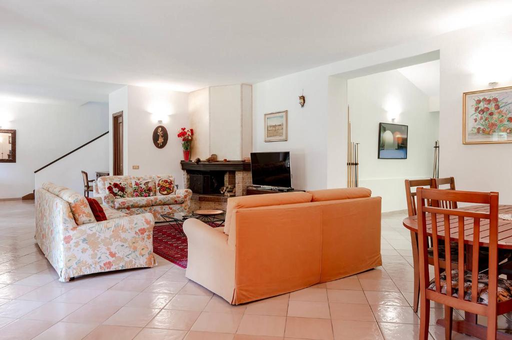 un salon avec deux canapés et une télévision dans l'établissement Villa Valleggia with pool, à Castelnuovo 31 autres photos