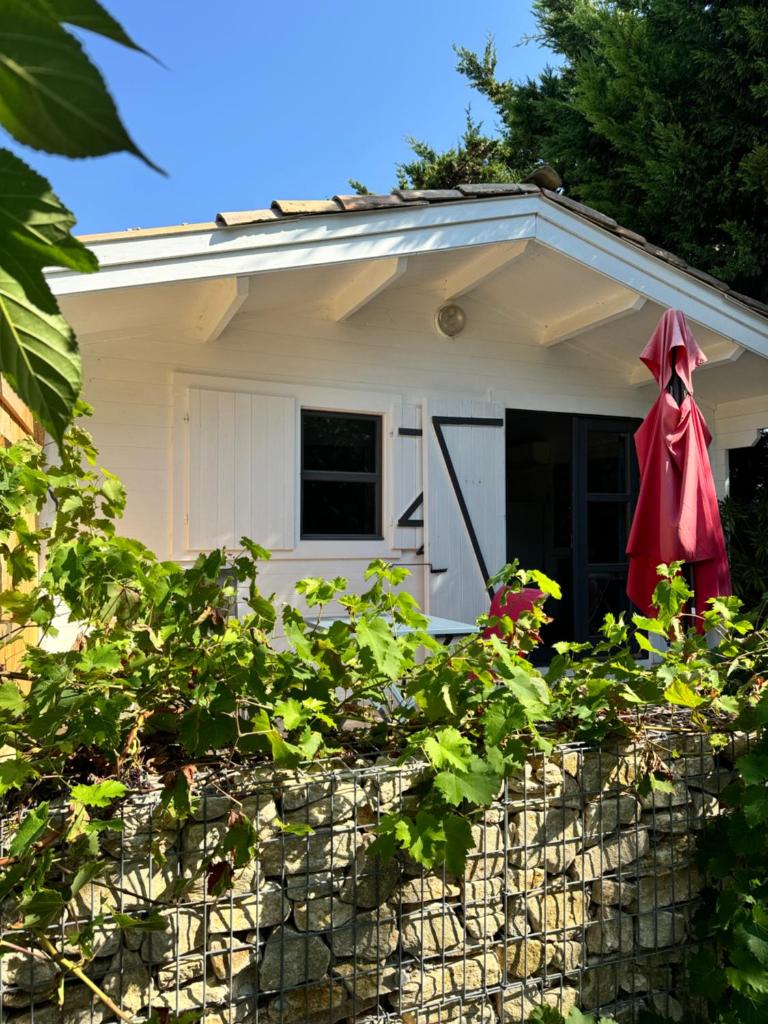 une maison avec un manteau rouge suspendu au-dessus d'un mur de pierre dans l'établissement Gîte La Fontaine de Rocoule, à Rochefort-en-Valdaine