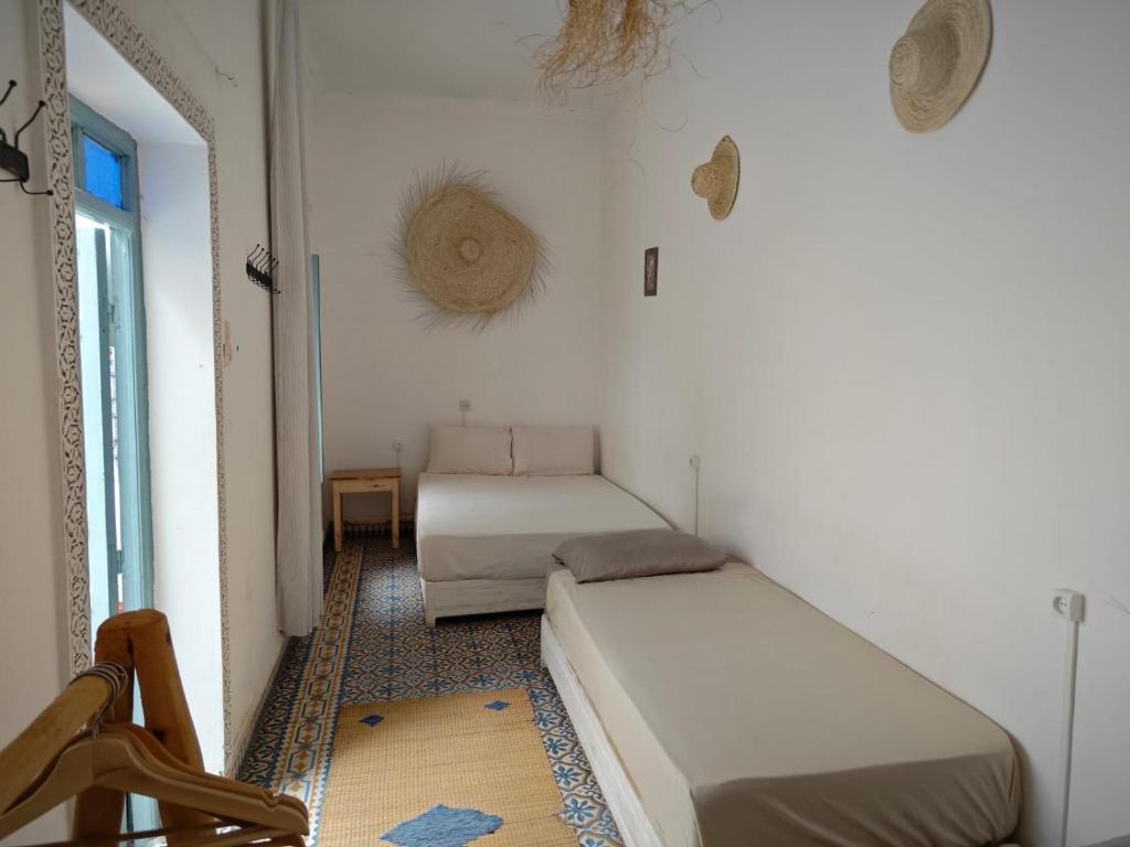 une petite chambre avec deux lits et une fenêtre dans l'établissement Hostel BE 20, à Marrakech