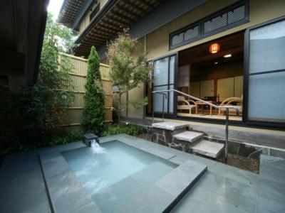 un patio avec une fontaine en face d'un bâtiment dans l'établissement Ryoutei Ryokan Takechiyo Kirishima Bettei, à Kirishima