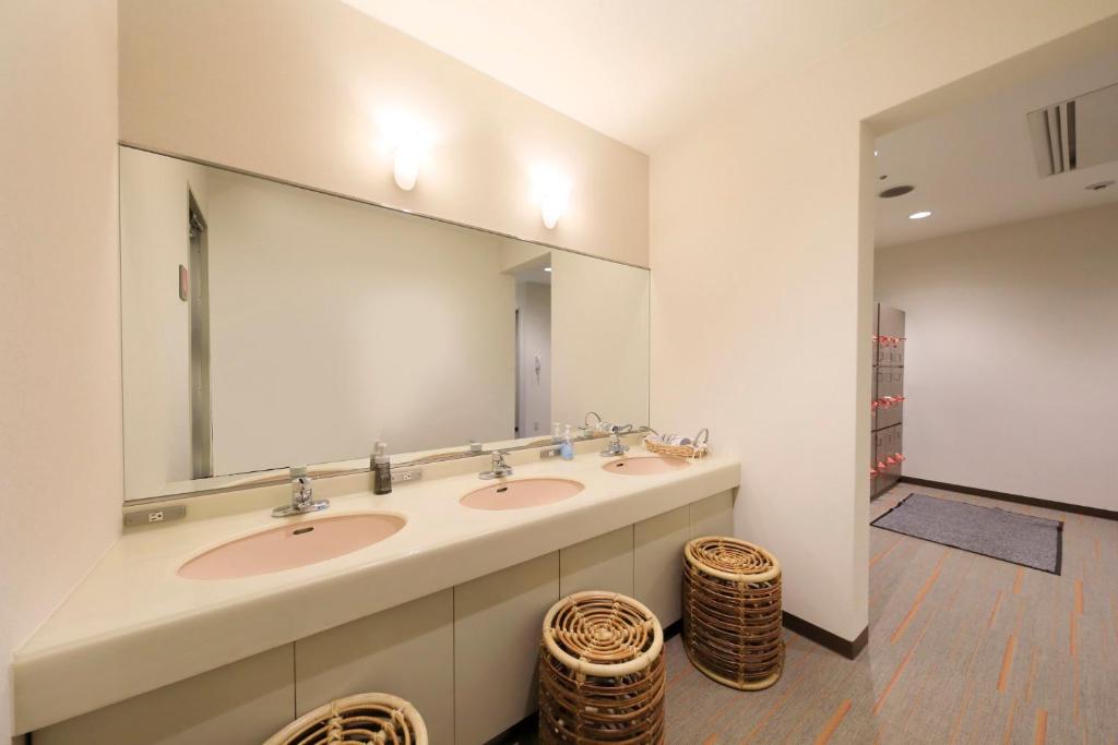 une salle de bain avec deux lavabos et un grand miroir dans l'établissement 有馬温泉ラコンテ有馬, à Kobe