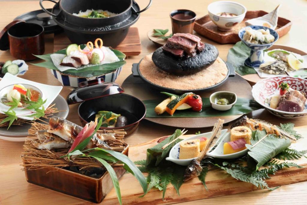 une table avec de nombreuses assiettes de nourriture dessus dans l'établissement Yufudake Ichibo no Yado Kirara, à Yufu