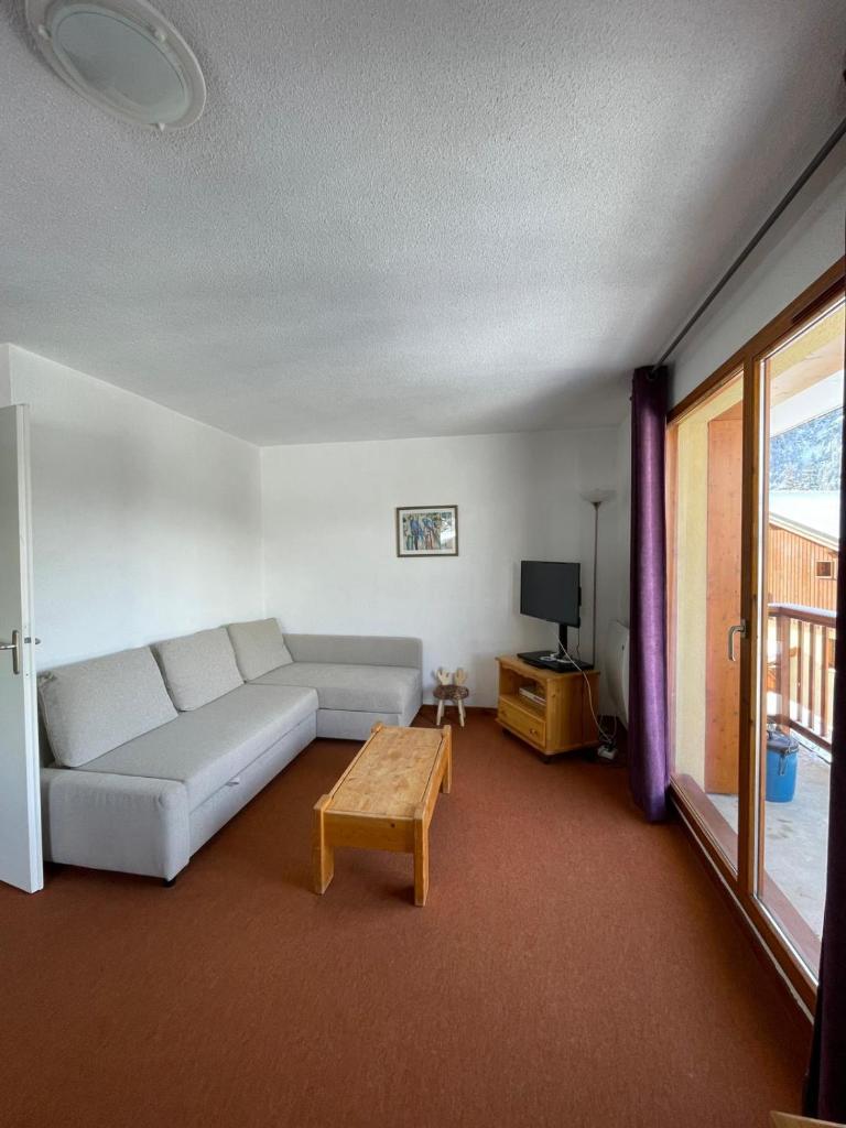 un salon avec un canapé et une table dans l'établissement Panorama Valfréjus, à Modane