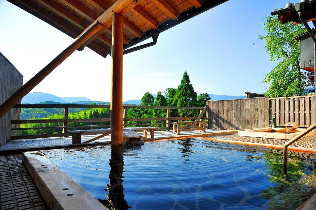 - une piscine dans un jardin avec une clôture en bois dans l'établissement Kafutei, à Yamaga