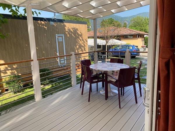 un patio avec une table et des chaises sur une terrasse dans l'établissement Hotel Villa Delle Palme, à Cannobio