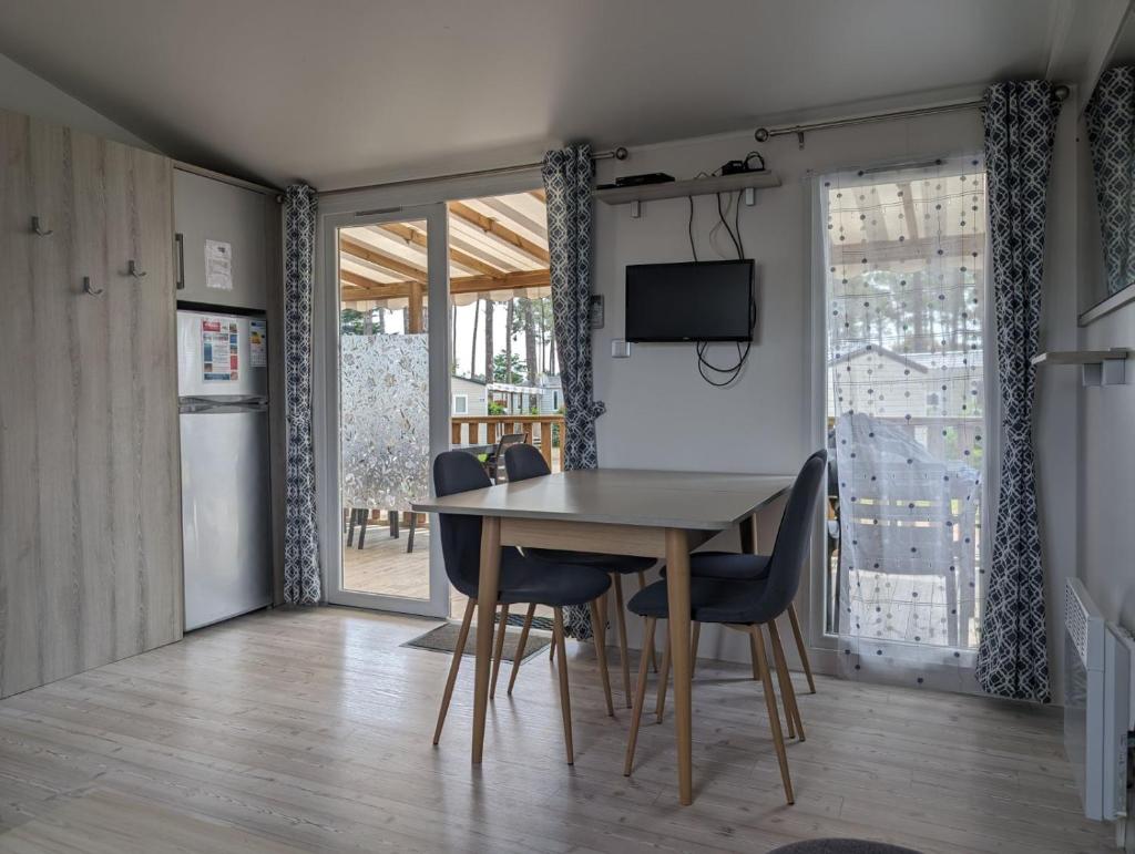 une salle à manger avec une table et des chaises dans l'établissement Mobil-home Mick et Stefie, à Saint-Julien-en-Born
