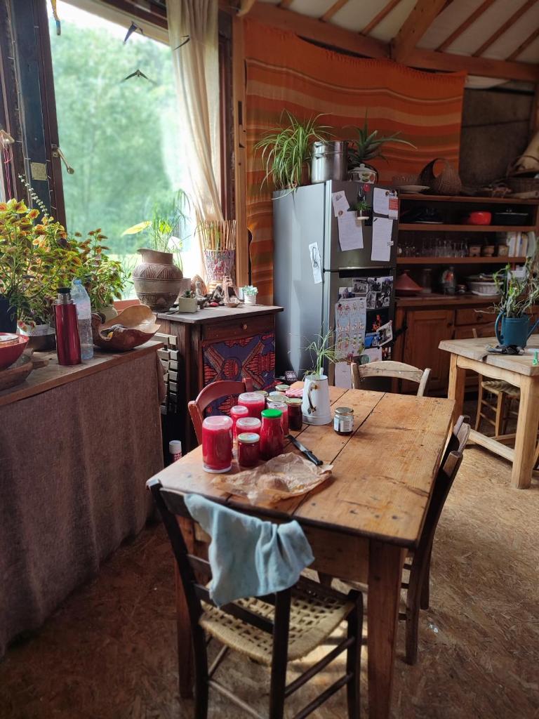 une cuisine avec une table en bois et un réfrigérateur dans l'établissement Grande yourte, à Boulc 10 autres photos