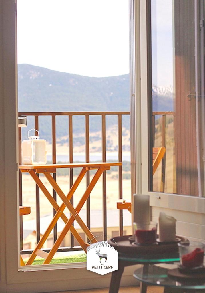 Cette chambre dispose d'un balcon avec une table. dans l'établissement Le Petit Ours & Le Petit Cerf - Studios vue lac & montagnes, aux Angles