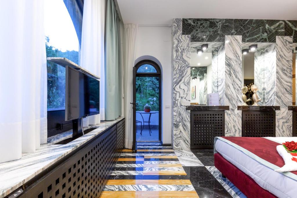 une chambre avec un lit, une télévision et une fenêtre dans l'établissement AMORE RENTALS - Villa Calisto, à Sant'Agnello