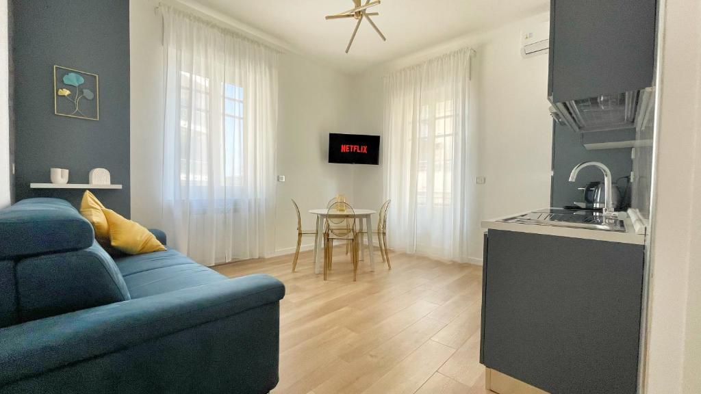 un salon avec un canapé bleu et une cuisine dans l'établissement Color Houses Pescara Centro, à Pescara