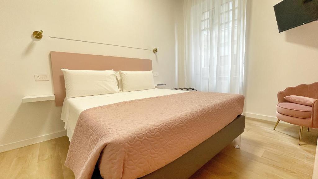 - une chambre avec un lit avec une couverture rose et une chaise dans l'établissement Color Houses Pescara Centro, à Pescara