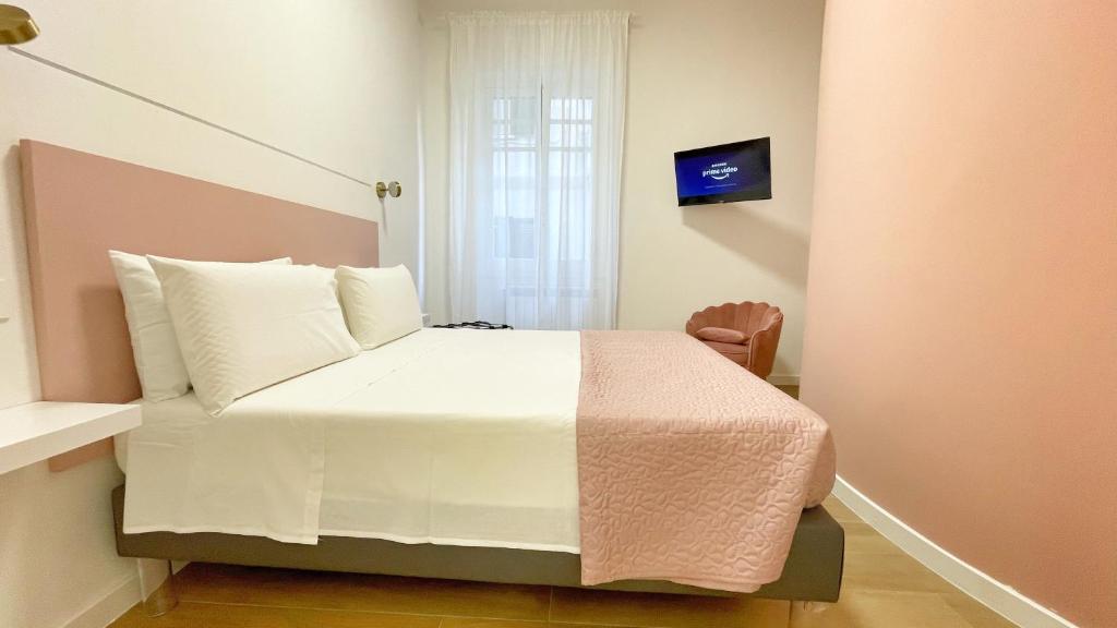 une chambre avec un lit avec des draps blancs et une fenêtre dans l'établissement Color Houses Pescara Centro, à Pescara