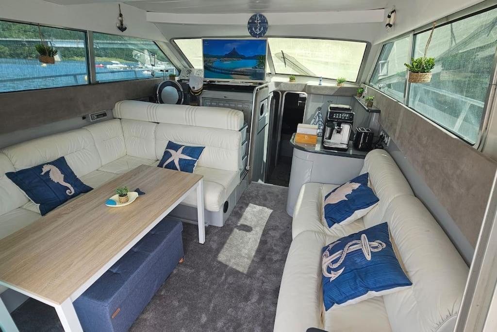 une camionnette avec deux canapés et une table à l'intérieur dans l'établissement Nuits insolites sur un bateau 12m en pleine nature, à Bully 37 autres photos