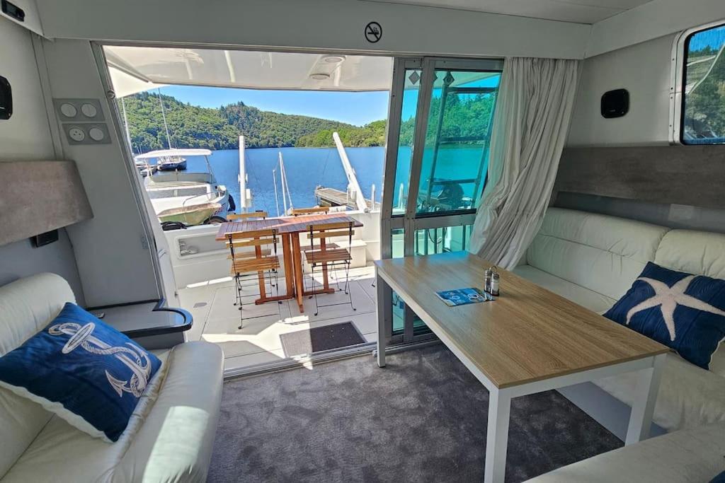 un salon avec une table sur un bateau dans l'établissement Nuits insolites sur un bateau 12m en pleine nature, à Bully