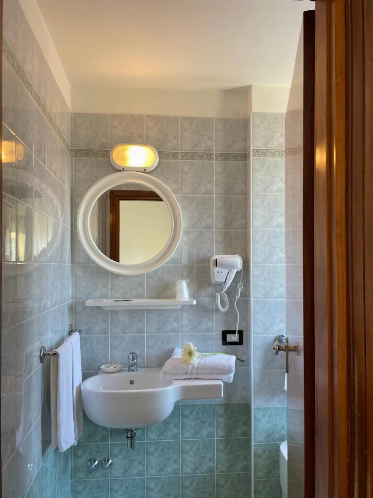 une salle de bain avec un lavabo et un miroir dans l'établissement HOTEL LA PLAYA, à Cervia