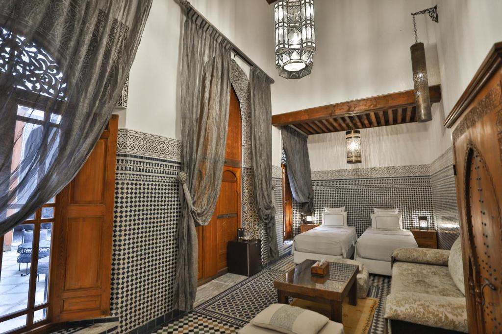 un salon avec deux lits et un canapé dans l'établissement Riad Layla, à Fès