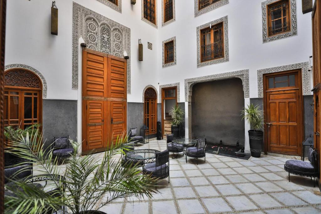 un bâtiment avec des portes en bois et une cour ornée de plantes dans l'établissement Riad Layla, à Fès