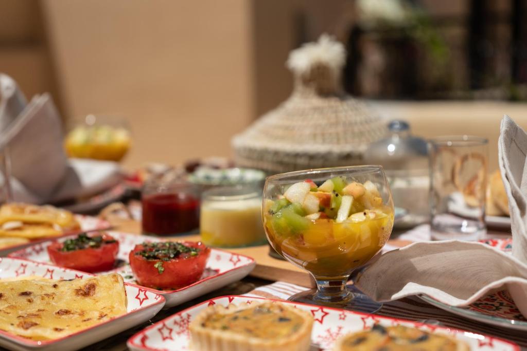 une table recouverte de assiettes de nourriture et d'un bol de fruits dans l'établissement Alibaba Riad, à Fès