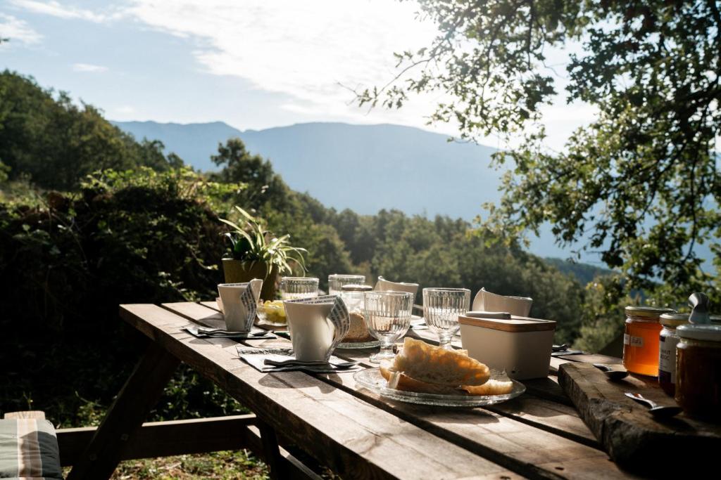 - une table en bois avec de la nourriture et des verres dans l'établissement Altitude Ecolodge Yourte, à Ilonse