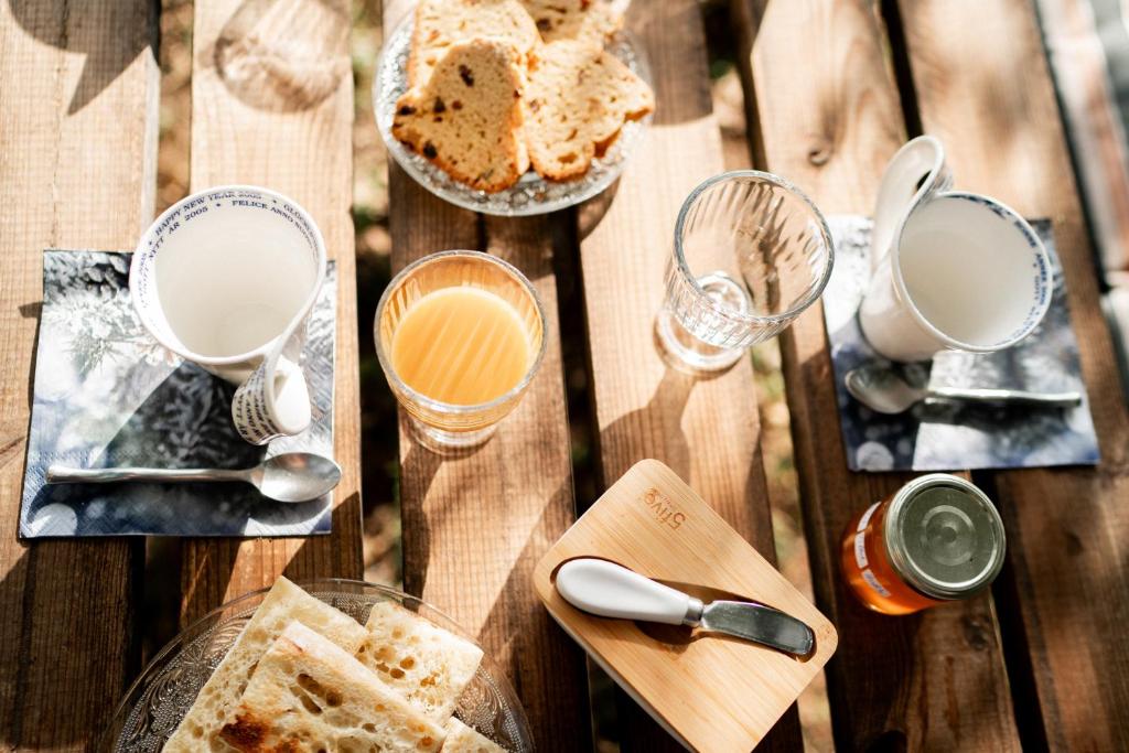 une table en bois avec deux assiettes de pain et des verres de lait dans l'établissement Altitude Ecolodge Yourte, à Ilonse