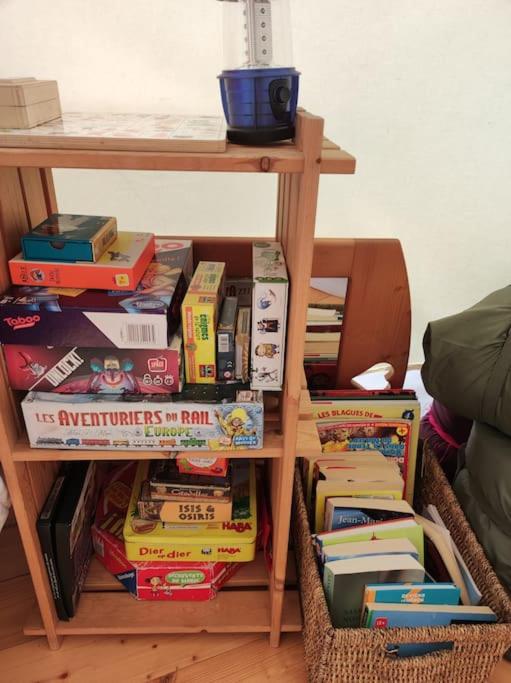 une pile de livres à côté d'une étagère dans l'établissement Dôme en pleine nature, à Lusse
