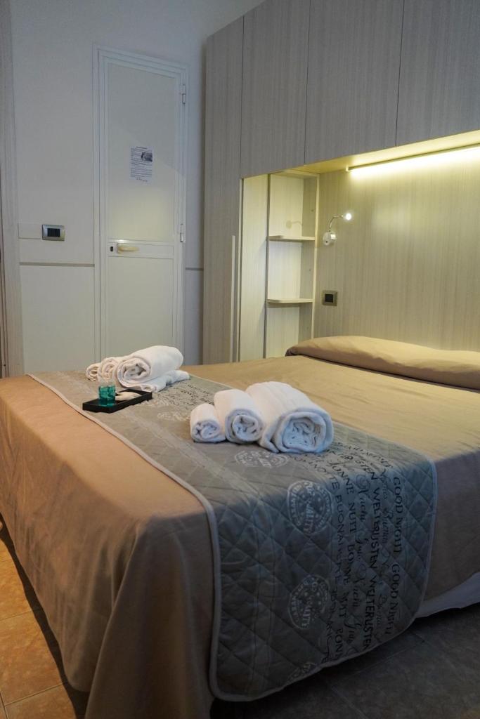 une chambre avec un lit avec des serviettes dessus dans l'établissement Hotel Cilene, à Viareggio