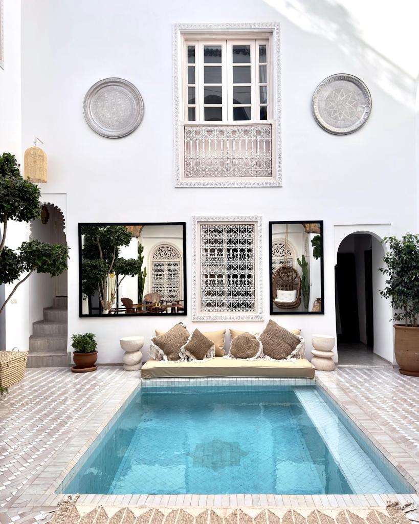 - un salon avec une piscine au milieu d'une maison dans l'établissement Riad Jalma, à Marrakech