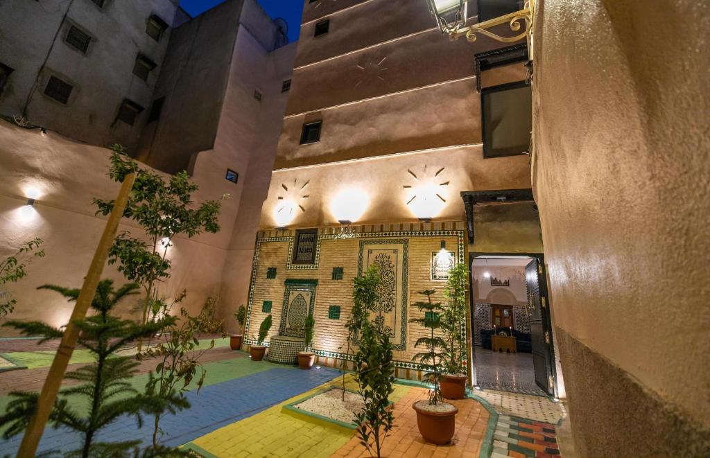 un bâtiment avec une cour agrémentée de plantes en pot dans l'établissement Riad Ridaya, à Fès