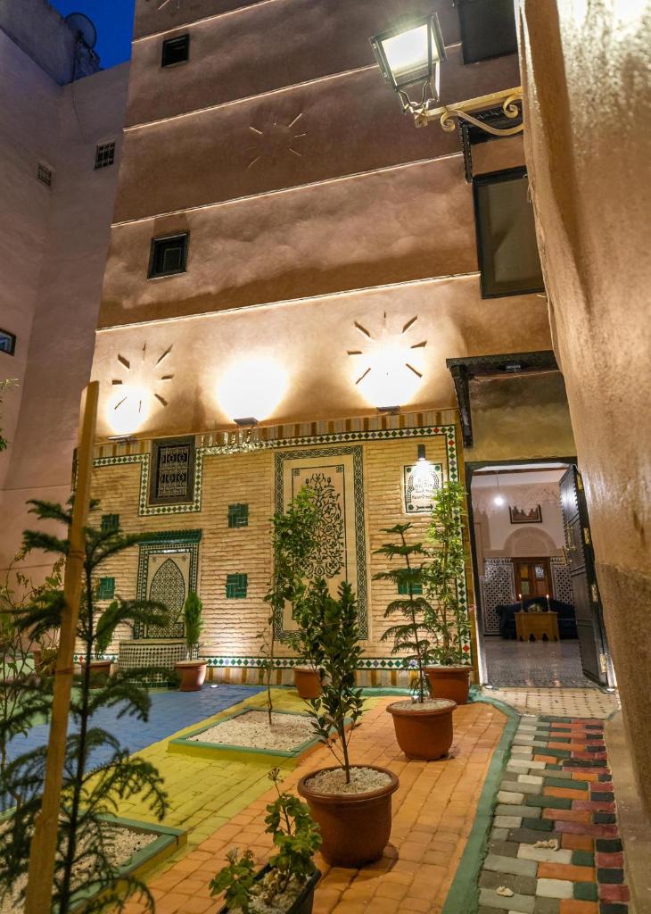 un bâtiment avec une cour agrémentée de plantes en pot dans l'établissement Riad Ridaya, à Fès