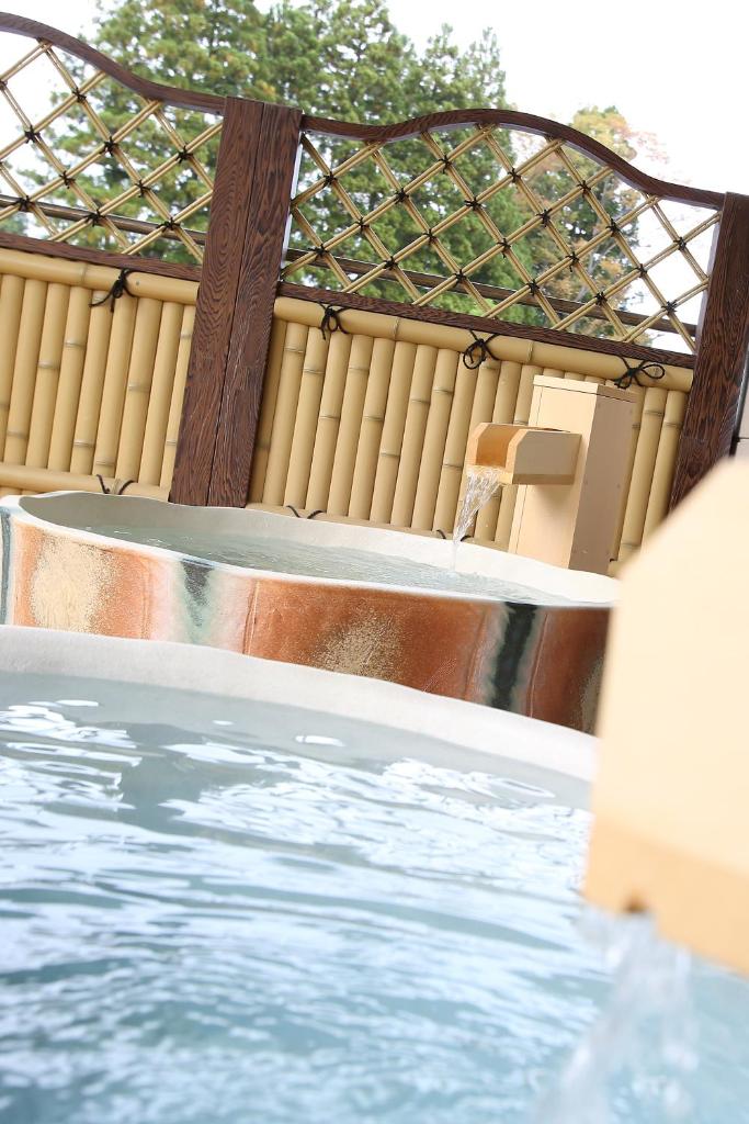 - une piscine avec une table et une baignoire dans l'établissement Niemonya, à Uozu