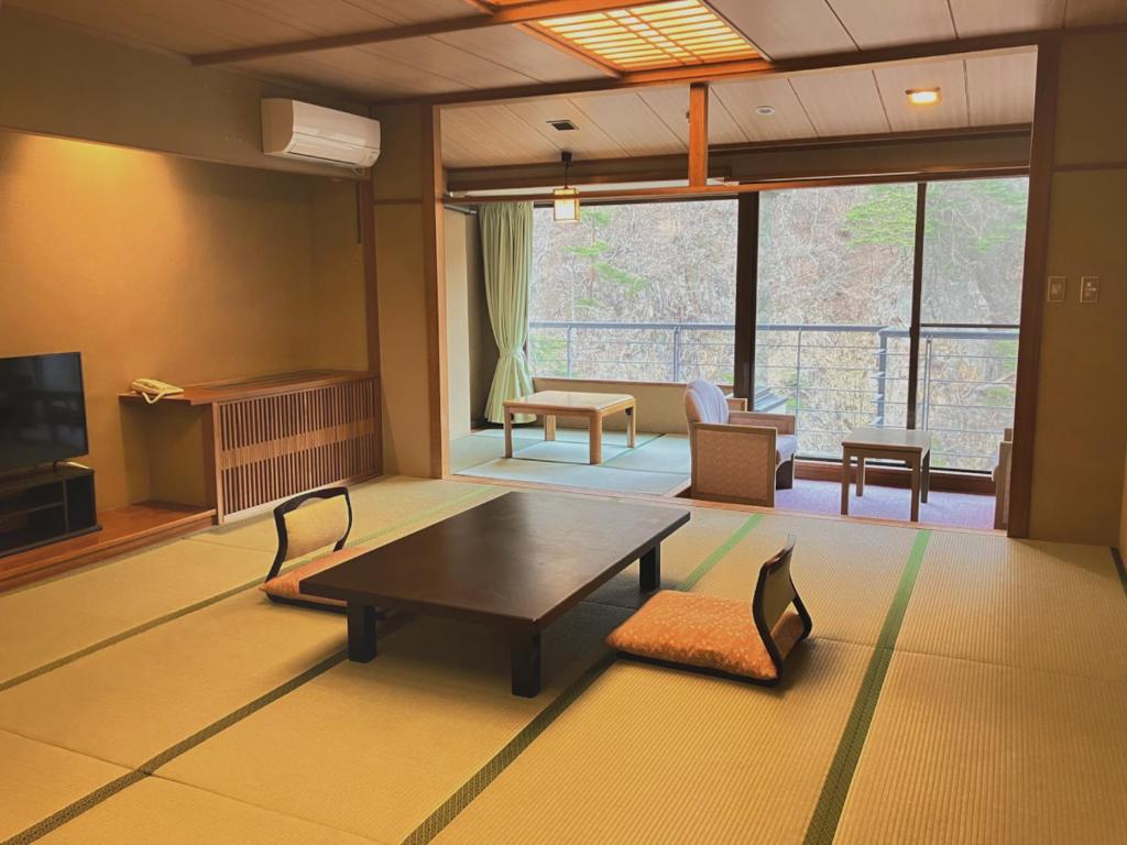un salon avec une table basse et un canapé dans l'établissement Hotel Yunishigawa, à Nikkō