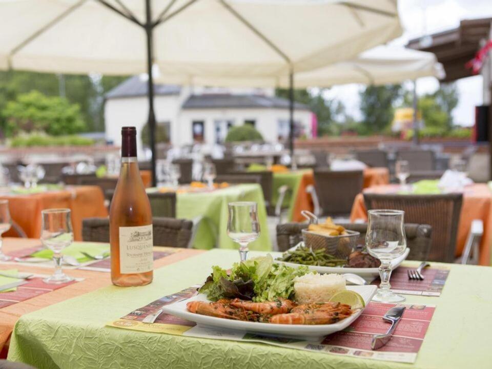 - une table avec une assiette de nourriture et une bouteille de vin dans l'établissement Mobilhome familial 3 chambres, à Onzain