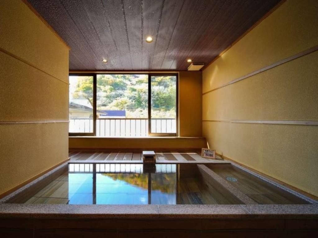 une chambre vide avec une piscine au milieu d'un bâtiment dans l'établissement Nakaya Ryokan, à Minakami