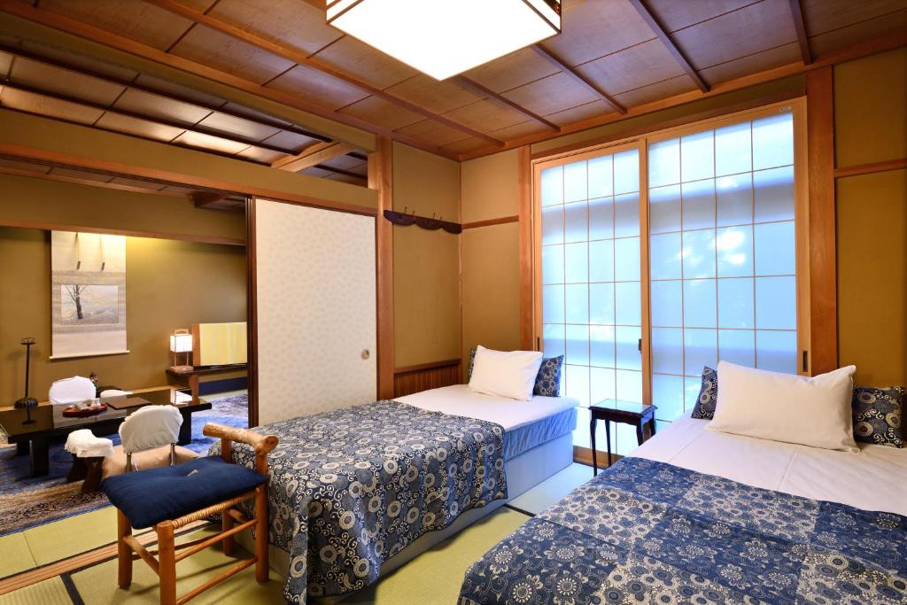 une chambre avec deux lits et une fenêtre dans l'établissement Seikoro Ryokan - Established in 1831, à Kyoto